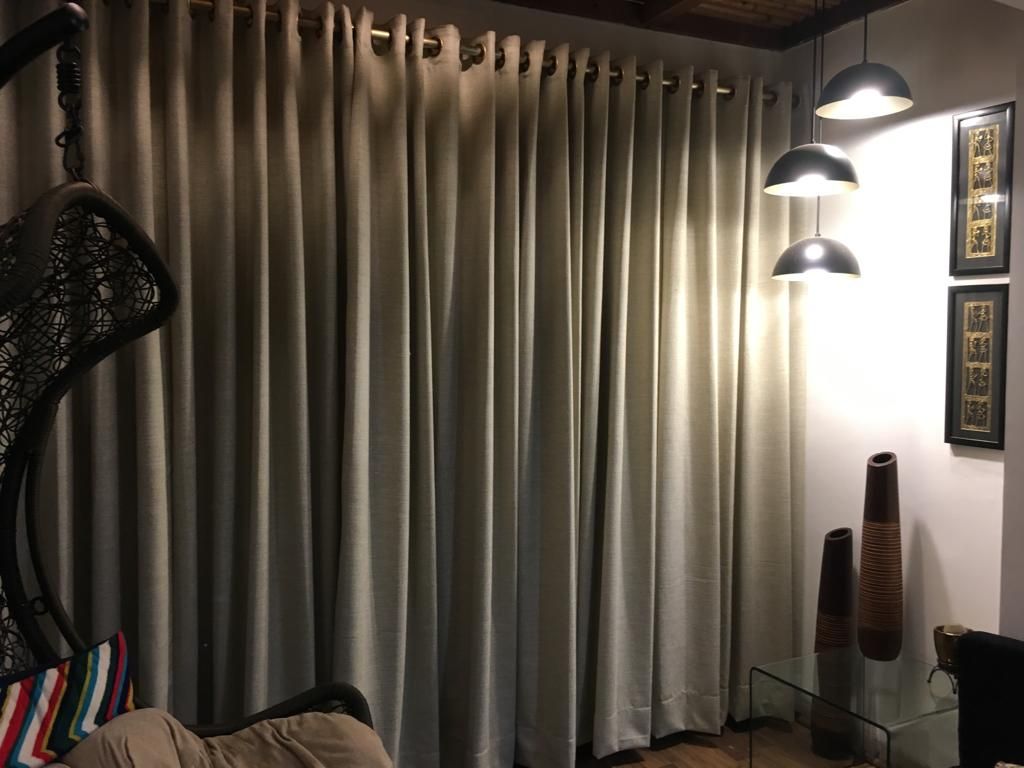 Grey-taupe eyelet curtains glowing under evening lamps