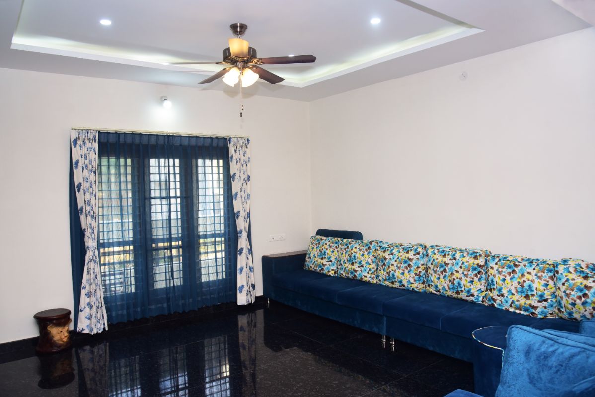 Living room with deep blue curtains and printed sheers at French windows