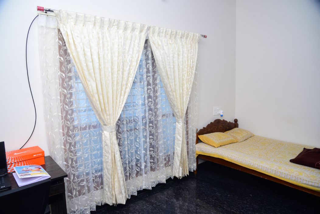 Ivory lace curtains tied back in a bedroom