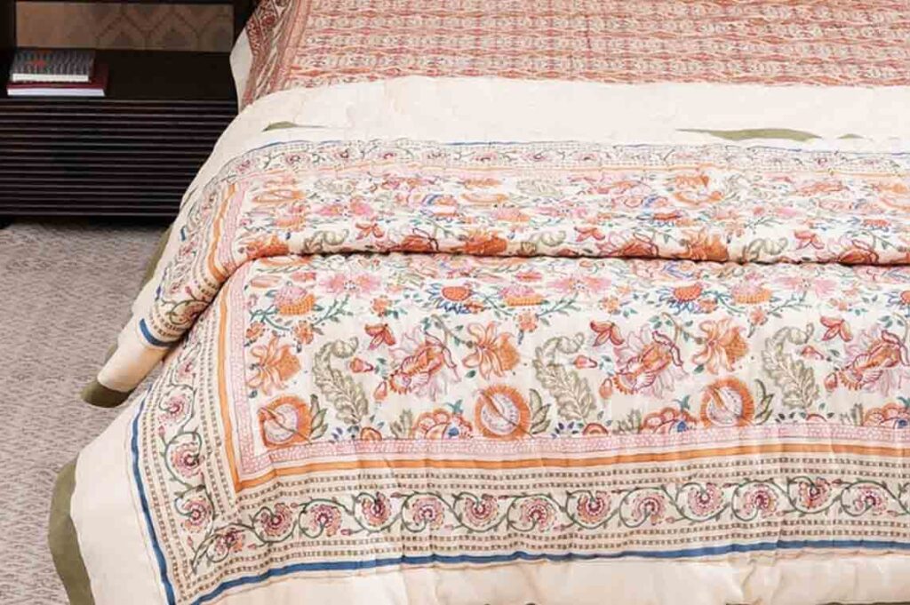 Block-printed floral quilt on a bed