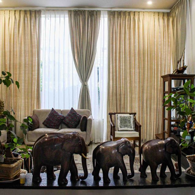 Pinch-pleated gold sheers across a living room